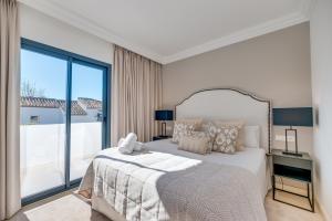 - une chambre avec un grand lit et une grande fenêtre dans l'établissement VACATION MARBELLA I Villa Lina, Golf Valley, Jacuzzi, Close to the Marina, à Marbella
