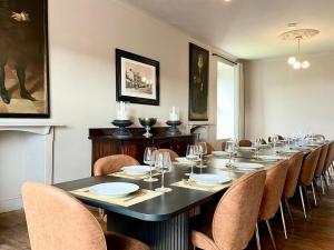 a long dining room with a long table and chairs at Bodorgan Inn By Birch Stays in Bodorgan
