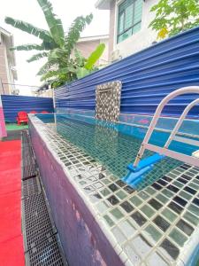 una piscina con una silla junto a una pared azul en 5Room Home2stay Hayyan Muslim Pool, en Melaka