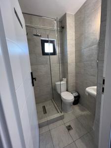 La salle de bains est pourvue de toilettes et d'une douche en verre. dans l'établissement Hotel AMA WORLD, à Constanţa
