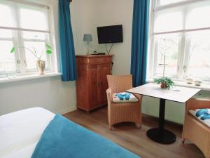 een kamer met een tafel, een tv en ramen bij Bed & Breakfast de Wandhorst in Gaanderen