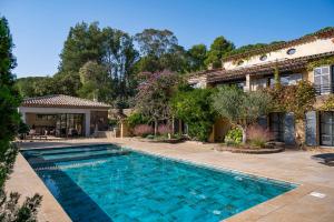 a swimming pool in front of a house at Le Clos de Mansart in Grimaud