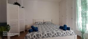 sypialnia z łóżkiem z niebieskimi poduszkami w obiekcie Loft 105 w Corralejo