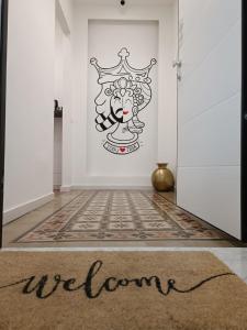 a room with a door with a welcome sign on the wall at Liotru Maisonne in Catania