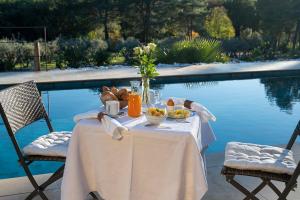 a table with food on it next to a pool at Le Clos de Mansart in Grimaud