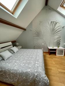 sypialnia z łóżkiem i ścianą z malowidłem roślinnym w obiekcie Duplex tout confort dans Boulogne w mieście Boulogne-sur-Mer