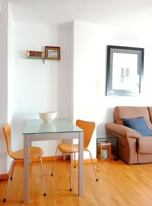 a table and chairs in a living room with a couch at Beachport in Viveiro