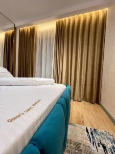 a bedroom with two beds and a window with curtains at Queens Luxury Apartments Tirana in Tirana