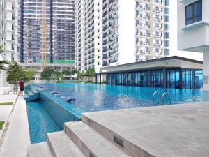 a large swimming pool in a city with tall buildings at Trefoil in Setia Alam