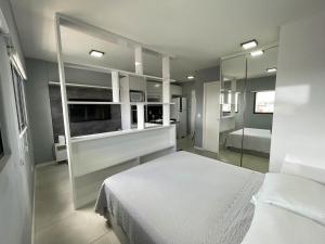1 dormitorio con cama blanca y espejo en Studio Time 1312 - Luxo - Ponta Verde - Maceió-AL, en Maceió