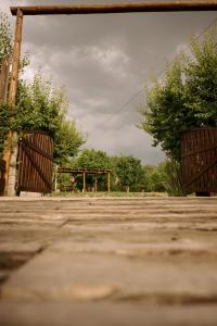 two wooden gates in a parking lot with trees at Jumani Cabañas in San Rafael