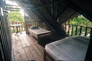 1 dormitorio con 2 camas y una mesa en la terraza en Maloka Napü - Ecodestinos, en Puerto Nariño