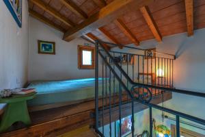 a room with a bed and a spiral staircase at Casetta delle mimose in Seccheto