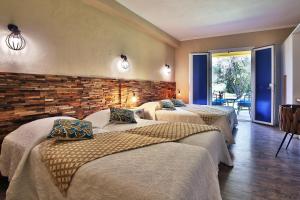 a room with three beds and a brick wall at Hotel du Pont de l'Oso in Cala Rossa