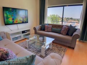 a living room with two couches and a flat screen tv at Apartment Beta - 2 Bedrooms, Private Rooftop Patio with Hot Tub, BBQ and View in Ferragudo