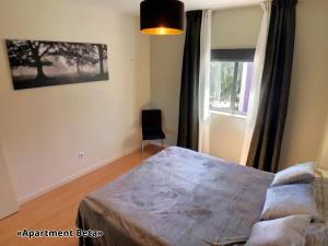 een slaapkamer met een bed en een raam bij Apartment Beta - 2 Bedrooms, Private Rooftop Patio with Hot Tub, BBQ and View in Ferragudo