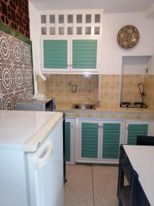 uma cozinha com armários verdes e persianas verdes em Residence Yasmina Agadir em Agadir