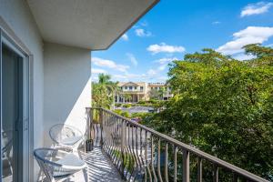 a balcony with chairs and a view of a building at Modern 1BR condo-5 min Bike ride to the beach in Naples