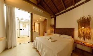 - une chambre avec un lit et une grande fenêtre dans l'établissement Pousada Nossa Casa Cumuruxatiba, à Cumuruxatiba
