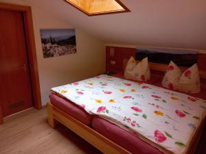 Un dormitorio con una cama con flores. en Ferienwohnung Schmid-Hof, en Oberwössen