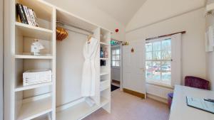 a walk in closet with white shelves and a window at The Devonshire Arms in Eckington +116 photos