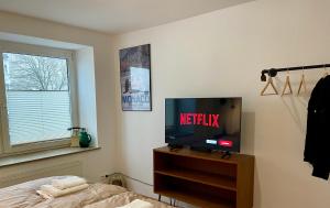 a bedroom with a tv on a wooden dresser at SPLENDiD: ☆Vintageflat In Center☆ in Hannover