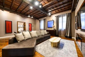 sala de estar con sofá y mesa en The Frattina - Luxury Serviced Apartment, en Roma