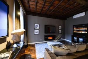 sala de estar con sofá y TV en The Frattina - Luxury Serviced Apartment, en Roma