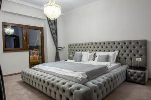 una camera da letto con un grande letto con una grande testiera di Chalet jolie Luxury Vila Sinaia a Sinaia
