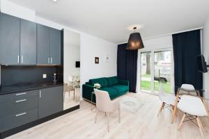 ein Wohnzimmer mit einem grünen Sofa und einem Tisch in der Unterkunft Apartamenty Rakowicka WAWELOFTS in Krakau