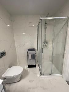 a white bathroom with a shower and a toilet at Retiro em Valença in Valença