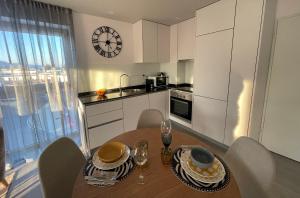 a kitchen with a table with chairs and a clock on the wall at Retiro em Valença in Valença