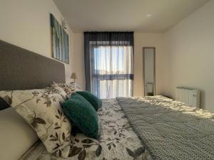 um quarto com uma cama com almofadas verdes e uma janela em Retiro em Valença em Valença