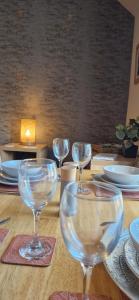 a table with wine glasses on a wooden table at Mains Street Retreat in Lockerbie