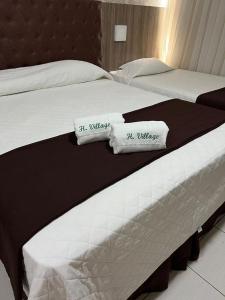 2 camas en una habitación de hotel con almohadas en Hotel Village, en Garanhuns