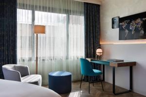 バルセロナにあるディプロマティック ホテル バルセロナのベッド、デスク、椅子が備わるホテルルームです。