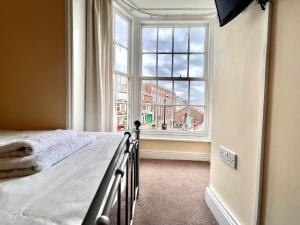 a bedroom with a bed and a large window at The Brunswick Hotel in Bridlington