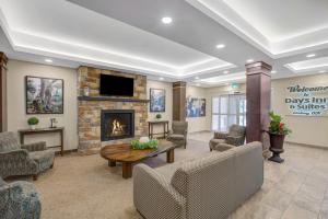 a lobby with a fireplace and a waiting room at Days Inn & Suites by Wyndham Lindsay in Lindsay