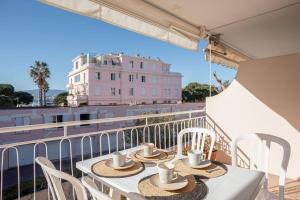 a table with hats and cups on a balcony at Le Petit Palais in Cannes