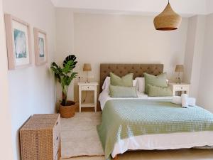 a white bedroom with two beds and two tables at Sotogrande Alboaire- Waterfront luxury 4 bedroom Apt in the Marina of Sotogrande in Sotogrande