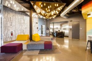 a lobby with colorful chairs and a couch at Aloft Austin Airport in Austin