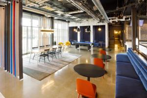 a room with tables and chairs and a pool table at Aloft Austin Airport in Austin
