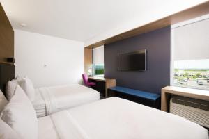 a hotel room with two beds and a tv at Aloft Austin Airport in Austin