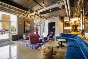 a large living room with a blue couch and chairs at Aloft Austin Airport in Austin