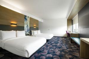 a hotel room with two beds and a desk at Aloft Austin Airport in Austin