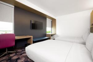 a bedroom with a bed and a desk and a tv at Aloft Austin Airport in Austin