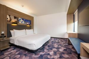 a bedroom with a large white bed and a blue couch at Aloft Austin Airport in Austin