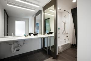 a bathroom with two sinks and a tub and a shower at Aloft Austin Airport in Austin