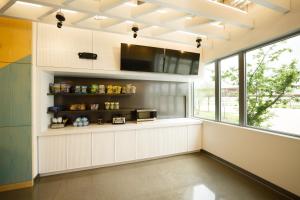 a kitchen with white cabinets and a large window at Aloft Austin Airport in Austin