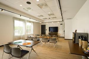a conference room with tables and chairs and a flat screen tv at Aloft Austin Airport in Austin